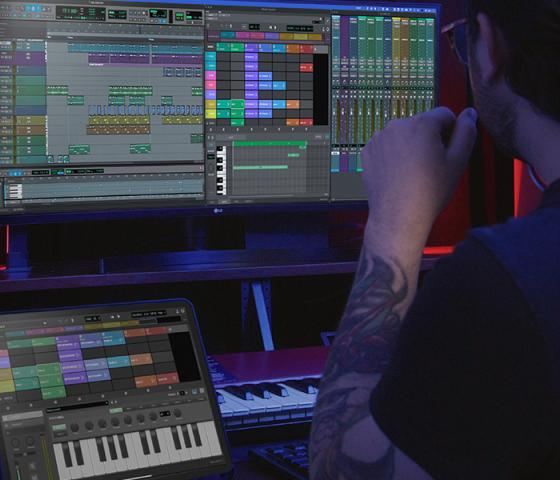 Man works on Pro Tools on computer and iPad in studio