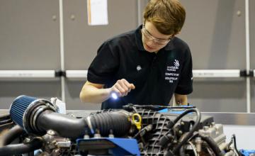 Student competitor at WorldSkills Championship examines an engine